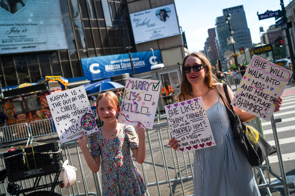 Taylor Swift fans hold signs outside of Madison Square Garden ahead of a reported wedding between singer Taylor Swift and National Football League player Travis Kelce on Friday, July 3, 2026, in New York. (AP Photo/Ryan Murphy)