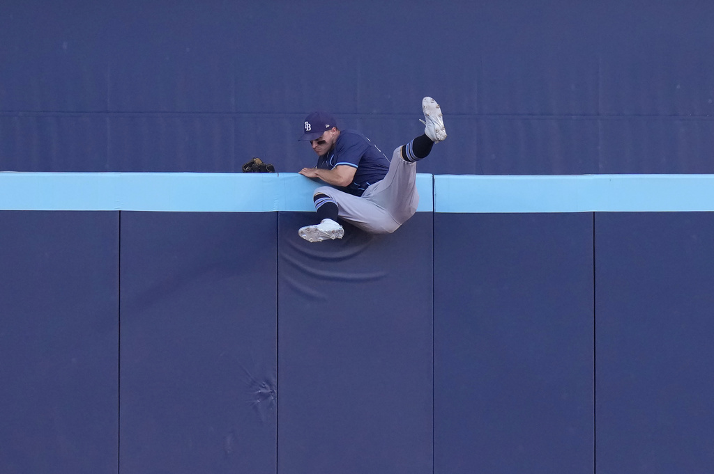 Tampa Bay Rays outfielder Jake Mangum cannot catch a two-run home run hit by Toronto Blue Jays' Alejandro Kirk during fifth-inning baseball game action in Toronto, Sunday, Sept. 28, 2025. (Chris Young/The Canadian Press via AP)