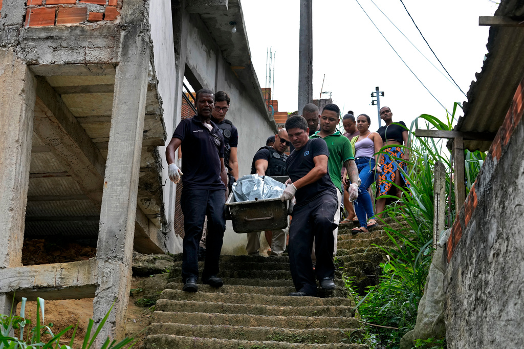 Forensic workers carry the body of a person killed during clashes between rival criminal gangs as the victim's relatives follow in the Jardim Esperanca neighborhood on the outskirts of Salvador, Bahia state, Brazil, Friday, Aug. 28, 2026. (AP Photo/Eraldo Peres)