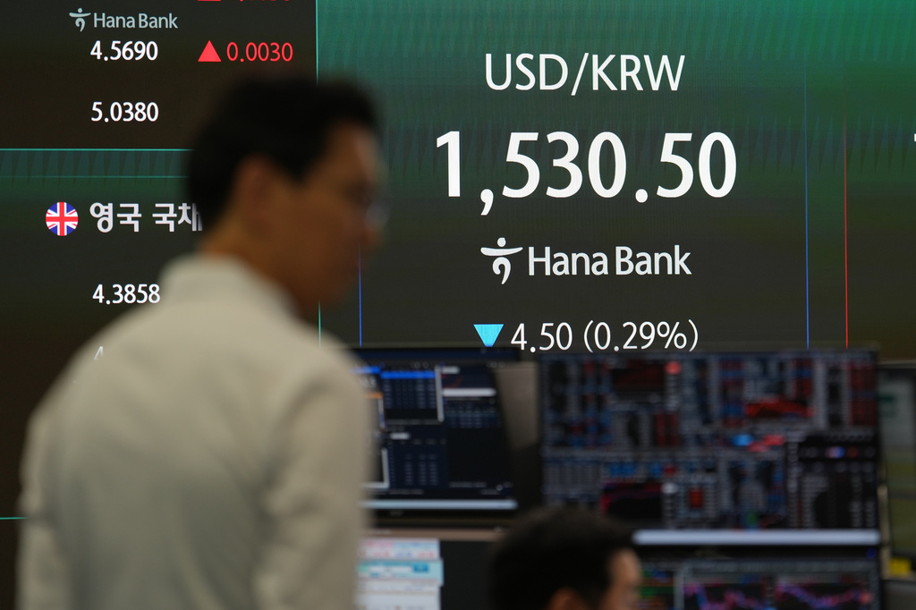 A dealer stands near the screens showing the foreign exchange rate between U.S. dollar and South Korean won at a dealing room of Hana Bank in Seoul, South Korea, Tuesday, June 9, 2026. (AP Photo/Lee Jin-man)