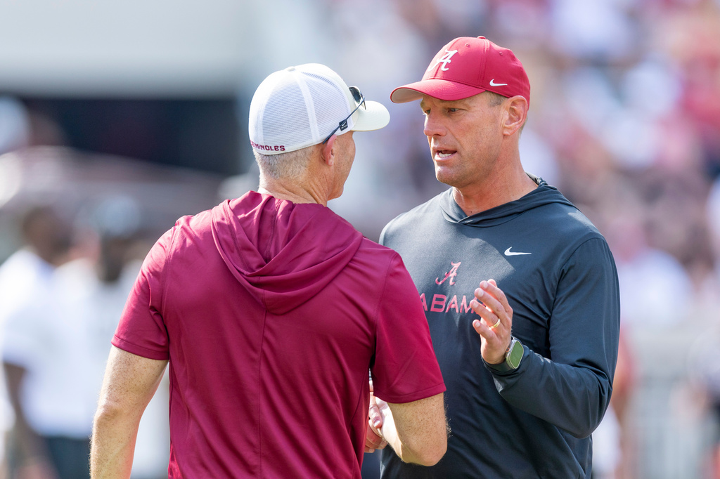 Alabama head coach Kalen DeBoer, right, meets with Florida State head coach Mike Norvell, left, before an NCAA college football game Saturday, Sept. 19, 2026, in Tuscaloosa, Ala. (AP Photo/Vasha Hunt)