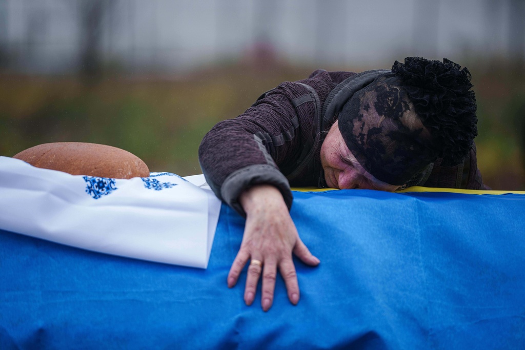 A mother cries at the coffin of her son Oleh Borovyk, a Ukrainian serviceman who was killed in fighting with Russian forces near Pokrovsk, during his funeral ceremony in Boiarka, Ukraine, on Wednesday, Dec. 3, 2025. (AP Photo/Evgeniy Maloletka)