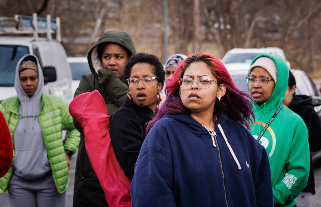 Family members and friends of North Forsyth High School students watch and wait in a parking lot across the street from the school after a fatal stabbing, Tuesday, Dec. 9, 2025, in Winston-Salem, N.C. (Allison Lee Isley/The Winston-Salem Journal via AP)