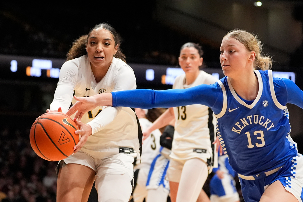 Vanderbilt forward Aiyana Mitchell (14) and Kentucky center Clara Strack (13) chase a loose ball during the first half of an NCAA college basketball game Sunday, Feb. 22, 2026, in Nashville, Tenn. (AP Photo/George Walker IV)
