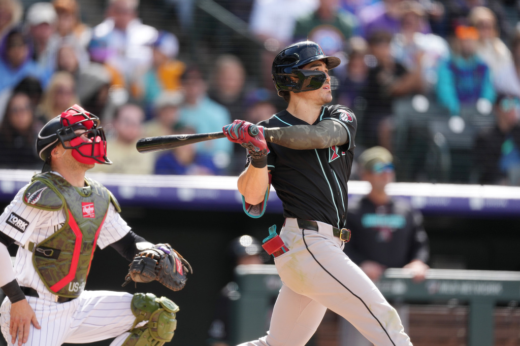 Arizona Diamondbacks' Corbin Carroll follows the flight of his two-run home run off Colorado Rockies starting pitcher Michael Lorenzen in the fourth inning of a baseball game, Sunday, May 17, 2026, in Denver. (AP Photo/David Zalubowski)
