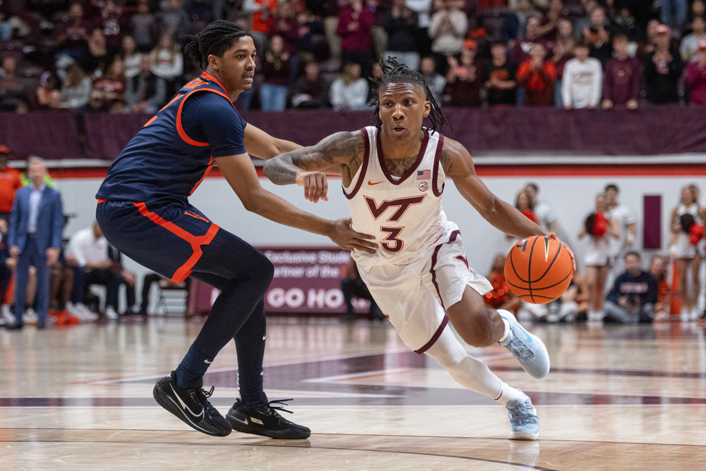 Virginia Tech guard Ben Hammond (3) drives by Virginia guard Elijah Gertrude (12) during the second half of an NCAA college basketball game, Wednesday, Dec. 31, 2025, in Blacksburg, Va. (AP Photo/Robert Simmons)