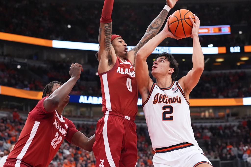 Illinois guard Andrej Stojakovic, right, drives to the basket against Alabama forward Aiden Sherrell, left, and guard Labaron Philon during the first half of an NCAA college basketball game in Chicago, Wednesday, Nov. 19, 2025. (AP Photo/Nam Y. Huh)