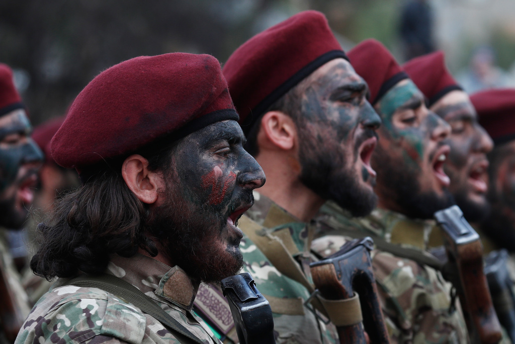 Fighters from the new Syrian army chant as they march during celebrations marking the first anniversary of the ousting of former President Bashar Assad in Damascus, Syria, Monday, Dec. 8, 2025. (AP Photo/Omar Sanadiki)