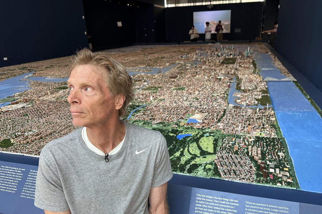 In this image taken with a smartphone=, truck driver Joe Macken poses in front of his scale model of New York City, Monday, Aug. 31, 2026, in New York. (AP Photo/Philip Marcelo)