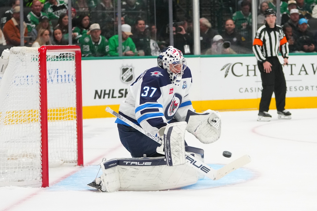 Winnipeg Jets goaltender Connor Hellebuyck blocks a shot by the Dallas Stars during the first period of an NHL hockey game Monday, Feb. 2, 2026, in Dallas. (AP Photo/Julio Cortez)