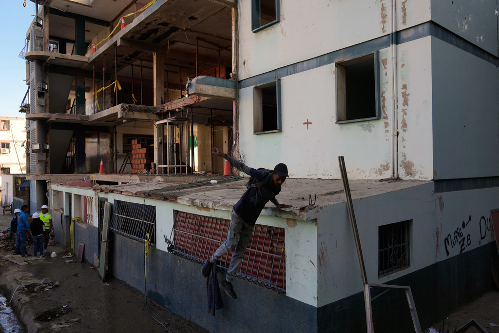 Workers repair damage to an apartment building hit in U.S. strikes during an operation to capture Venezuelan President Nicolas Maduro in La Guaira, Venezuela, Saturday, Jan. 10, 2026. (AP Photo/Ariana Cubillos)
