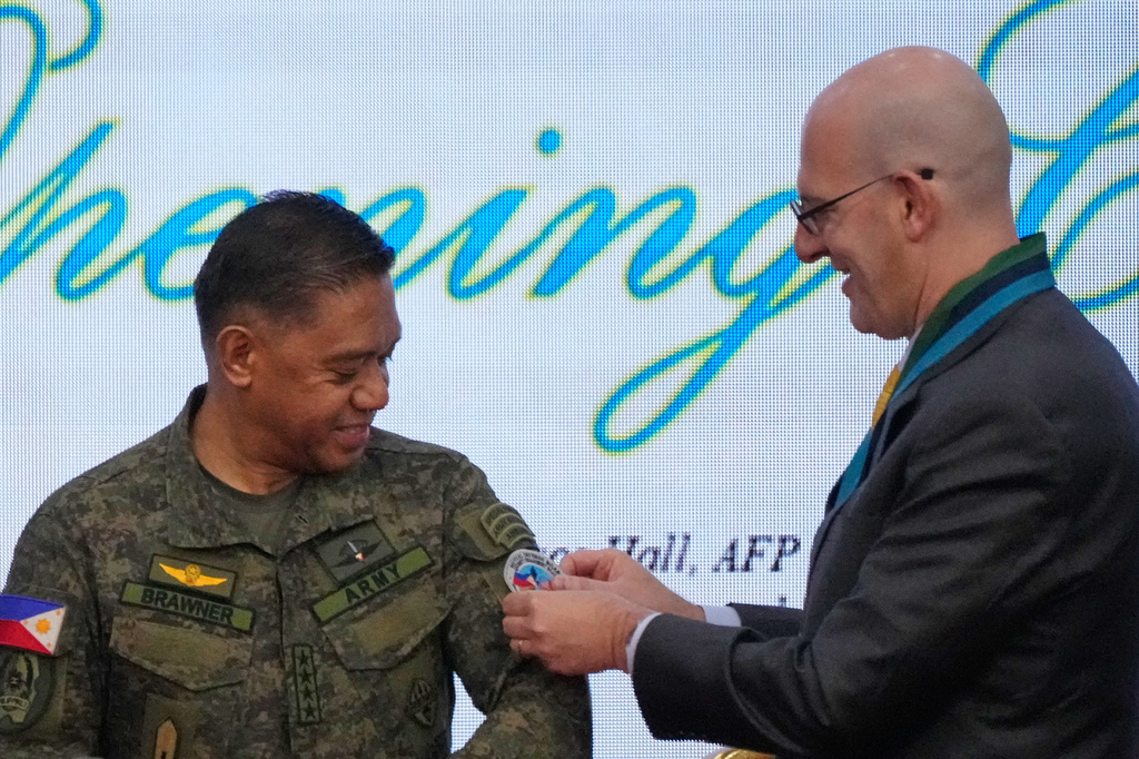 Philippine military Chief Gen. Romeo Brawner, left, has the "Balikatan" patch from U.S. Charge d' Affaires, Ad interim Y. Robert Ewing during the opening ceremonies of the joint military exercise dubbed "Balikatan" or "Shoulder to Shoulder," Monday, April 20, 2026, at Camp Aguinaldo military headquarters in Quezon city, Philippines. (AP Photo/Aaron Favila)