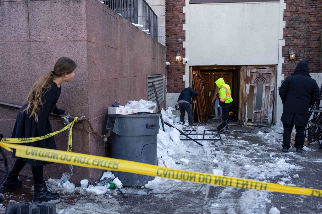 FILE - A person watches the scene where a car slammed into the entrance of the Chabad Lubavitch world headquarters, Jan. 29, 2026, in New York. (AP Photo/Yuki Iwamura, file)