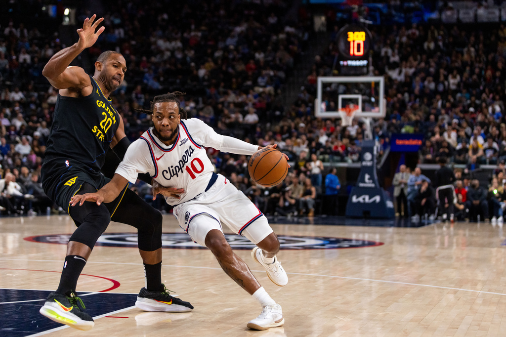 Los Angeles Clippers guard Darius Garland (10) drives against Golden State Warriors center Al Horford (20) during the first half of an NBA basketball game, Sunday, April 12, 2026, in Inglewood, Calif. (AP Photo/Ethan Swope)