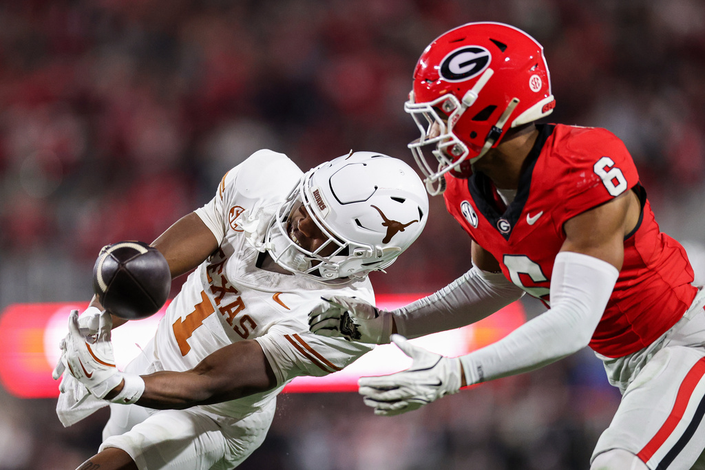 Texas wide receiver Ryan Wingo (1) attempts to catch a pass defended by Georgia defensive back Daylen Everette (6) during the first half of an NCAA college football game, Saturday, Nov. 15, 2025, in Athens, Ga. (AP Photo/Colin Hubbard)
