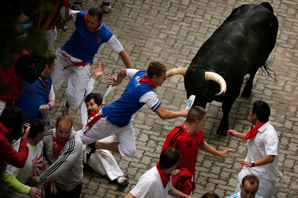 FILE - U.S. runner Bill Hillmann, 35, from Chicago, center left, falls seconds before a Victoriano del Rio ranch fighting bull gored him on his right leg during the running of the bulls of the San Fermin festival, in Pamplona, Spain, Wednesday, July 9, 2014. (AP Photo/Daniel Ochoa de Olza, File)