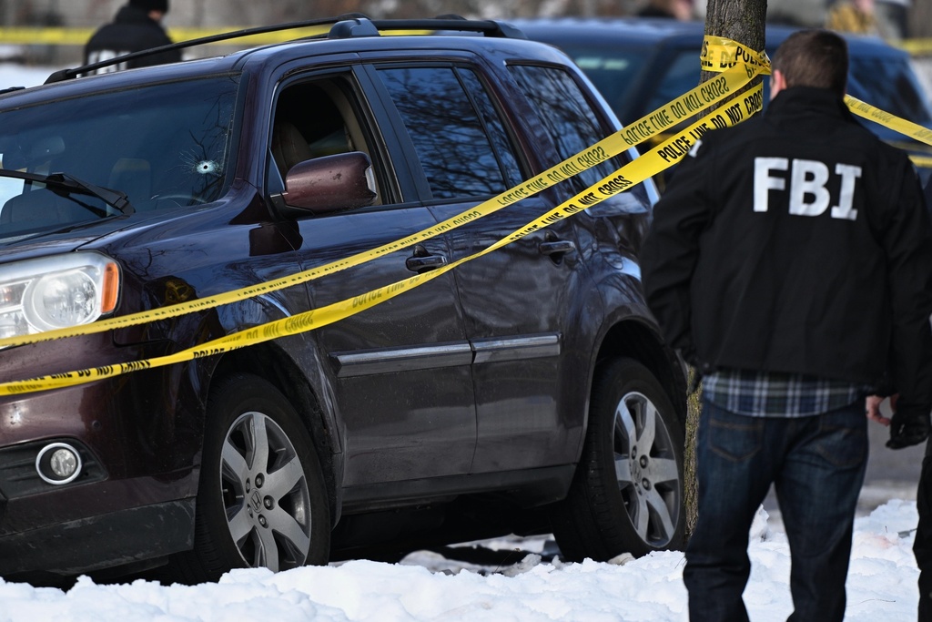 A bullet hole is seen in the windshield as law enforcement officers work the scene of a shooting involving federal law enforcement agents, Wednesday, Jan. 7, 2026, in Minneapolis. (AP Photo/Tom Baker)