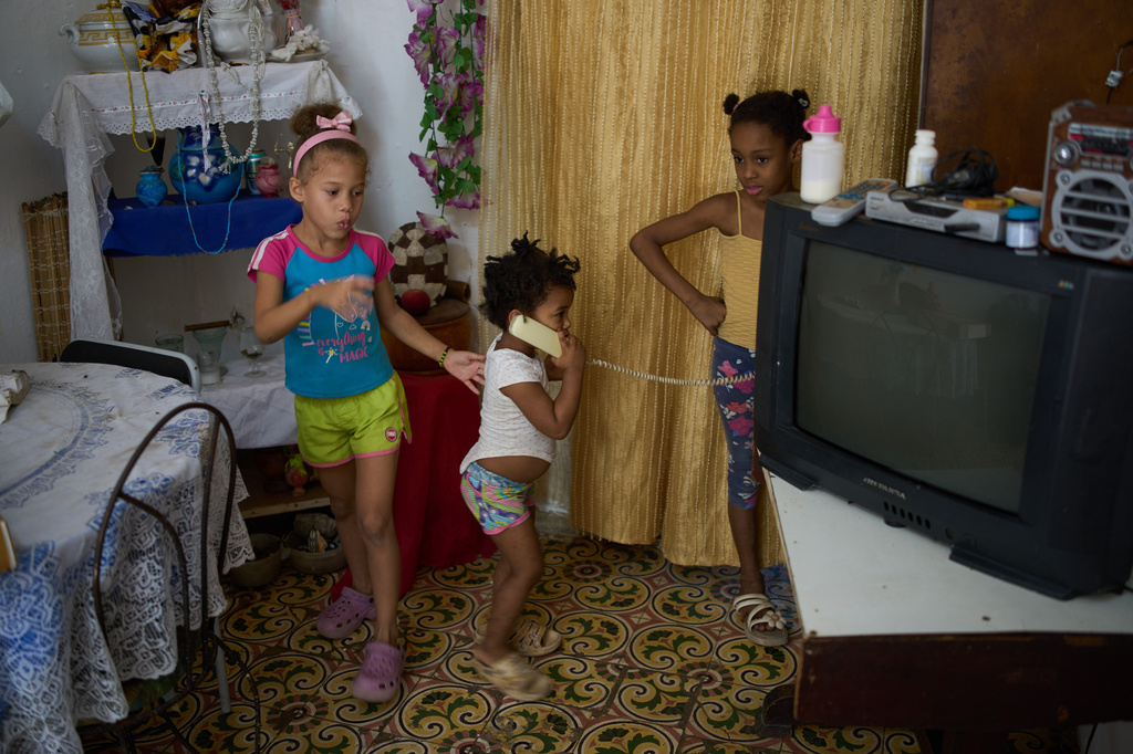 Edianet, left, and her sister Seinet, center, play with a friend at their home in Havana, Cuba, Wednesday, March 25, 2026. (AP Photo/Ramon Espinosa)