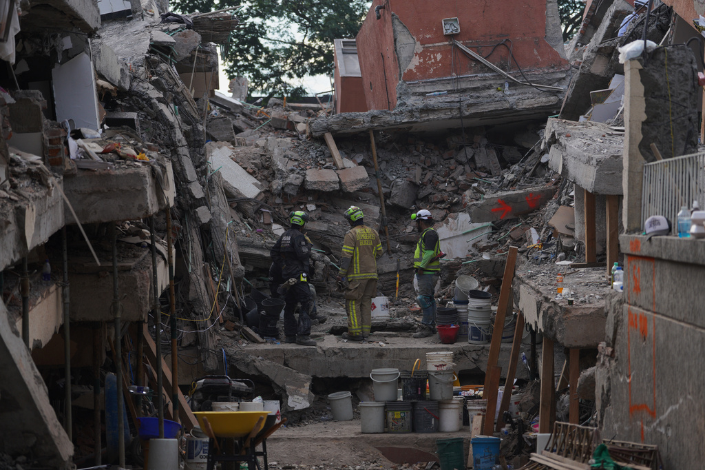 Firefighters search through the rubble three days after an earthquake struck Cali, Colombia, Thursday, Aug. 13, 2026. (AP Photo/Ivan Valencia)