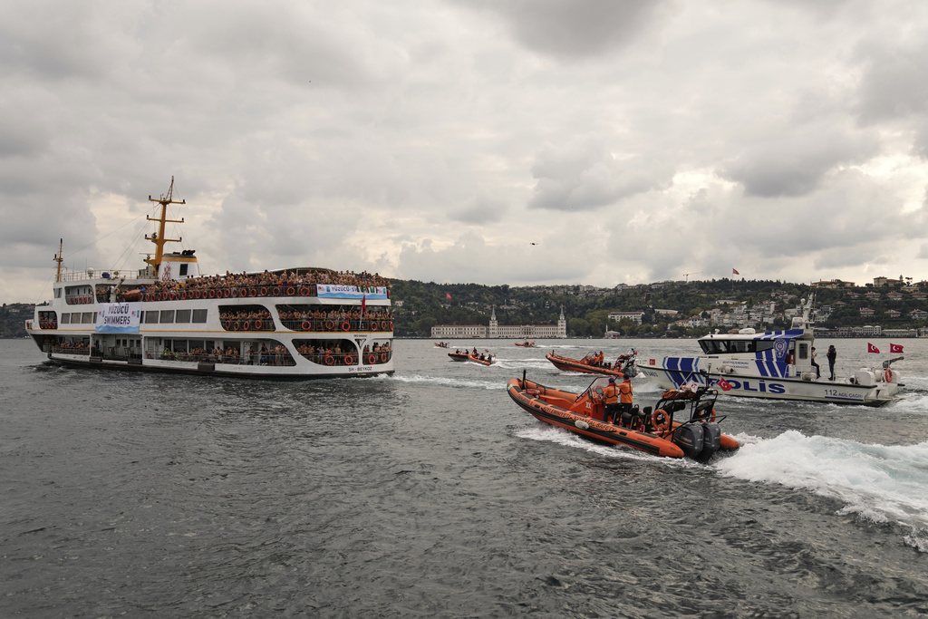 Competitors aboard a ferry heading to the start line of a 6.5-kilometer swimming race across the Bosphorus Strait, from the Asian side to the European side, in Istanbul, Turkey, Sunday, Aug. 24, 2025. (AP Photo/Khalil Hamra)