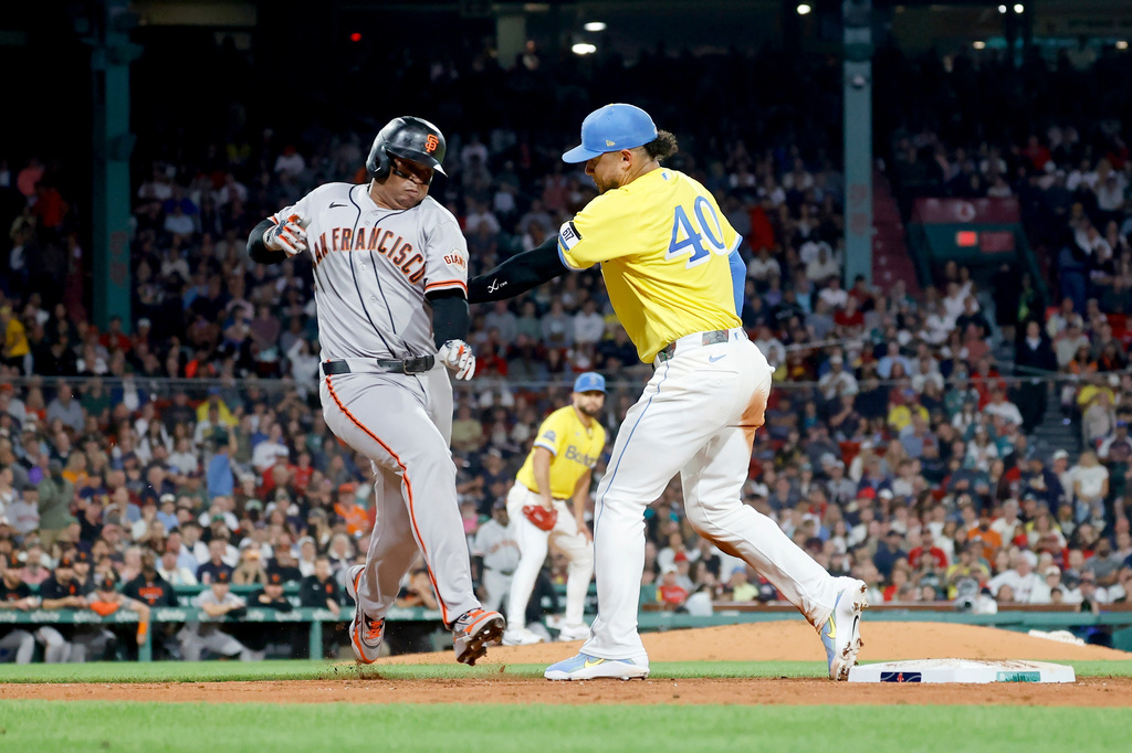 Boston Red Sox first baseman Willson Contreras (40) tags out San Francisco Giants' Rafael Devers, left, at first during the fifth inning of a baseball game Saturday, Aug. 22, 2026, in Boston. (AP Photo/Mary Schwalm)