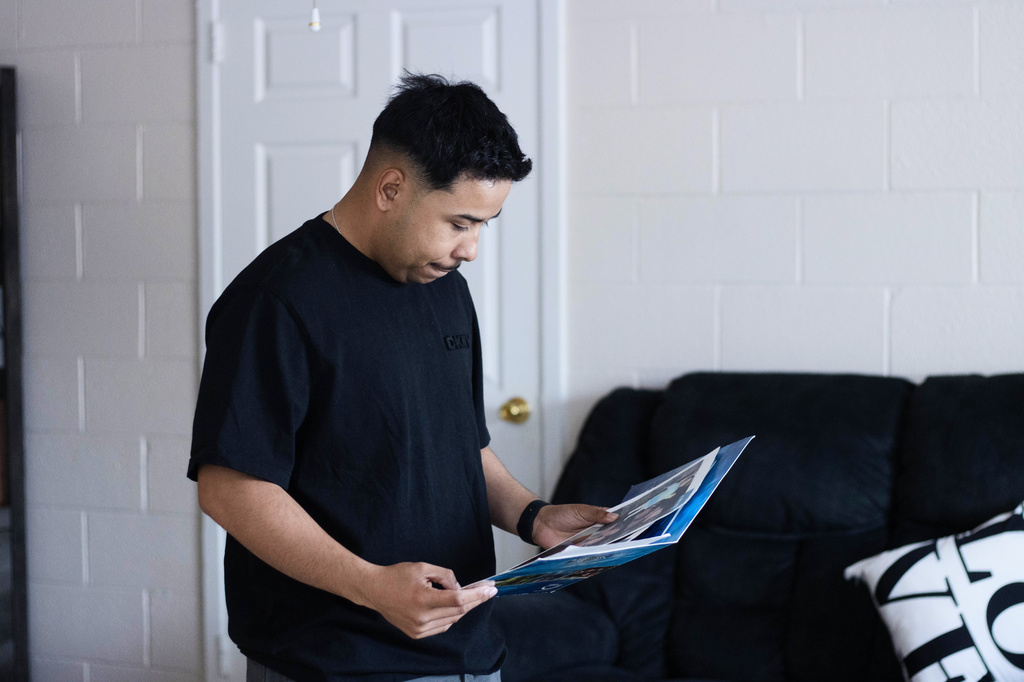 Army Sgt. Hedar Leonel Turcios Juarez, whose wife Cristy has been detained by immigration authorities, looks at family photos at home in El Paso, Texas, July 21, 2026. (AP Photo/Ryan Romero)