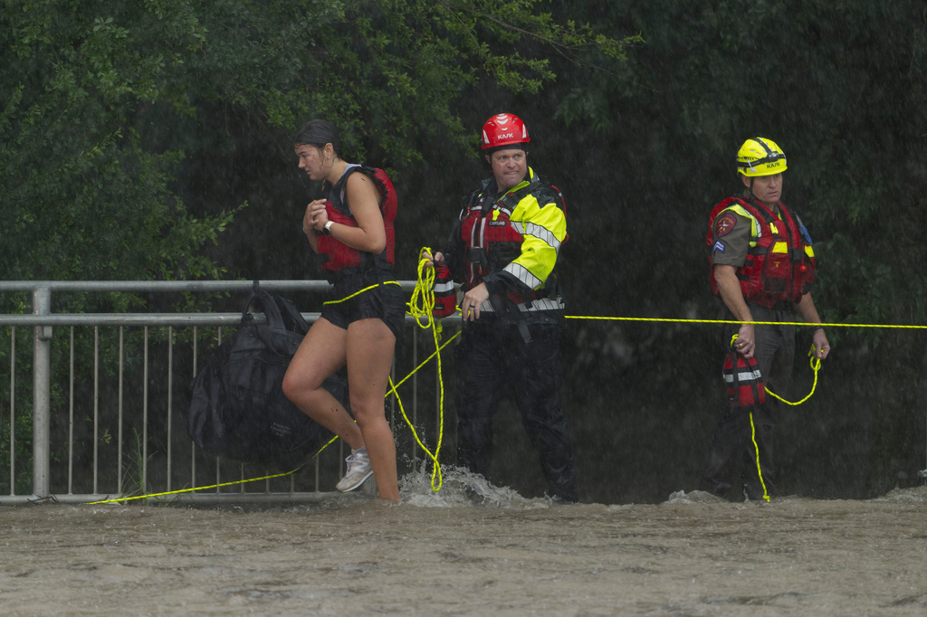 Members of the Boerne Fire Dept. rescue a woman from flood waters on Wednesday, July 15, 2026, in Boerne, Texas. (AP Photo/Darren Abate)