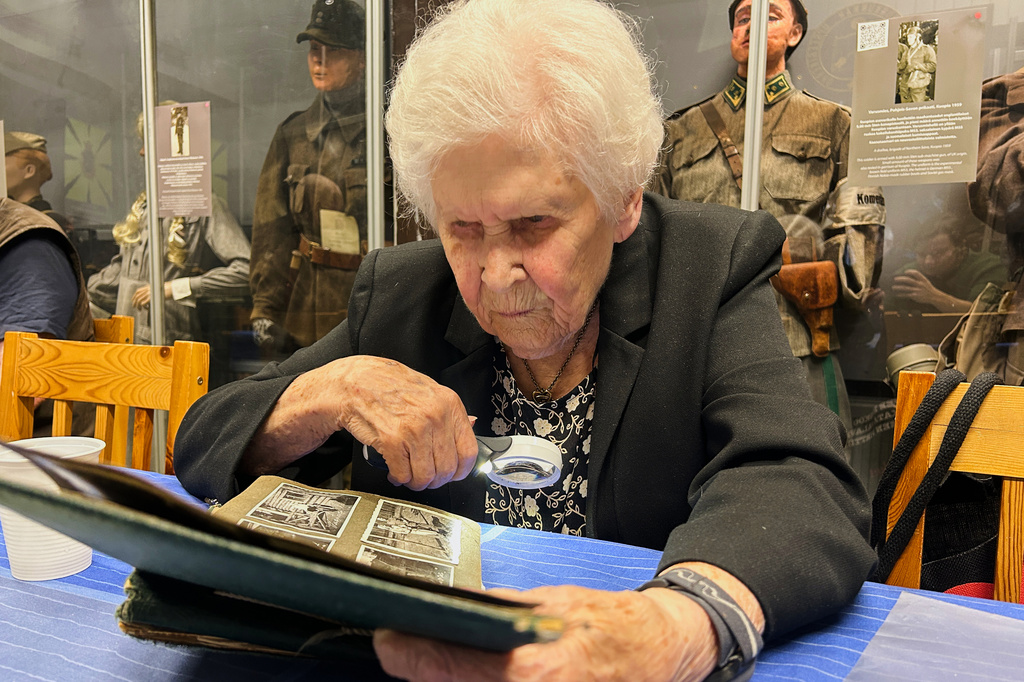 Pirkko Naukkarinen, a Finnish war veteran, looks over photos from World War II in an album at a museum in Kuopio, Finland, Tuesday, Sept. 1, 2026. (AP Photo/Emma Burrows)