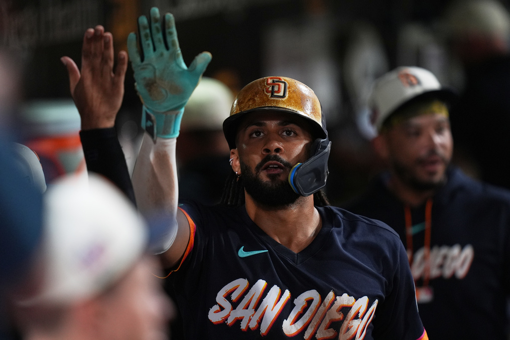 San Diego Padres' Fernando Tatis Jr. celebrates with teammates after scoring off an RBI single by Manny Machado during the fifth inning of a baseball game against the Minnesota Twins Friday, Aug. 21, 2026, in San Diego. (AP Photo/Gregory Bull)