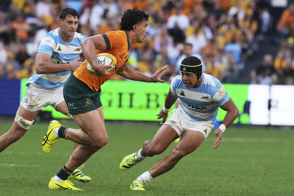 Australia's Joseph-Aukuso Suaalii, centre, attempts to fend off Argentina's Santiago Chocobares, right, during the Rugby Championship test match between the Wallabies and the Pumas in Sydney, Australia, Saturday, Sept. 13, 2025. (AP Photo/Mark Baker)