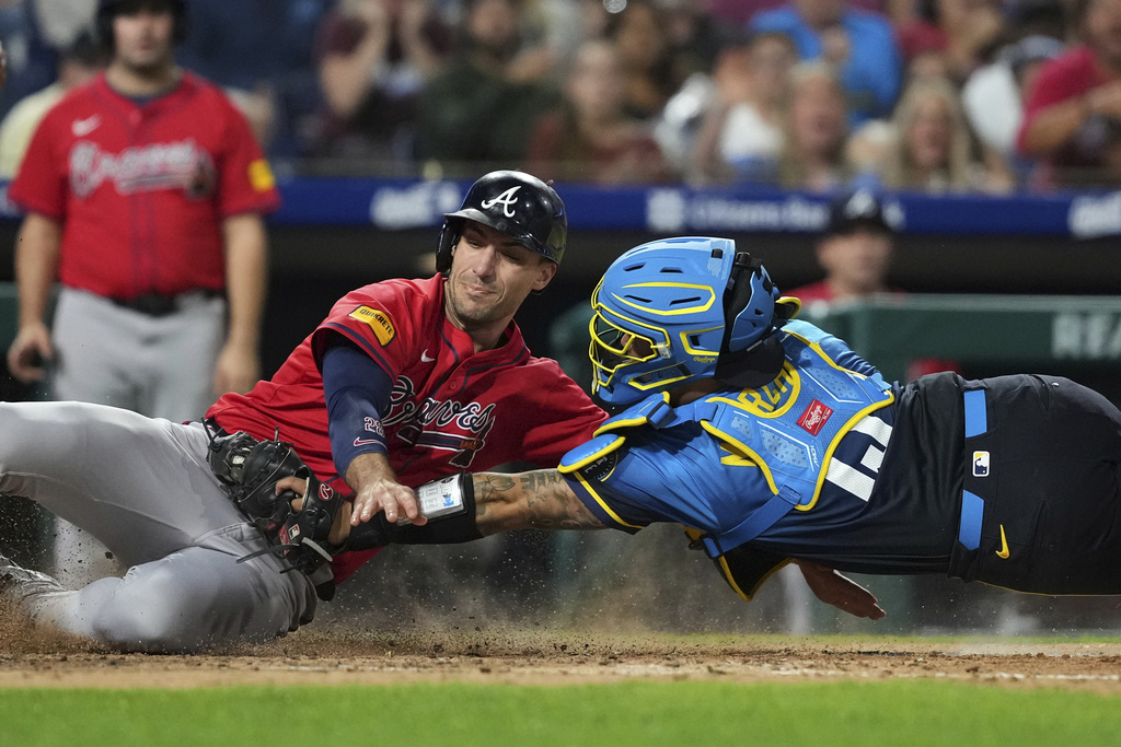 Atlanta Braves' Matt Olson, left, is tagged out by Philadelphia Phillies catcher Rafael Marchán after trying to score on a line out by Marcell Ozuna during the fifth inning of a baseball game Friday, Aug. 29, 2025, in Philadelphia. (AP Photo/Matt Slocum)