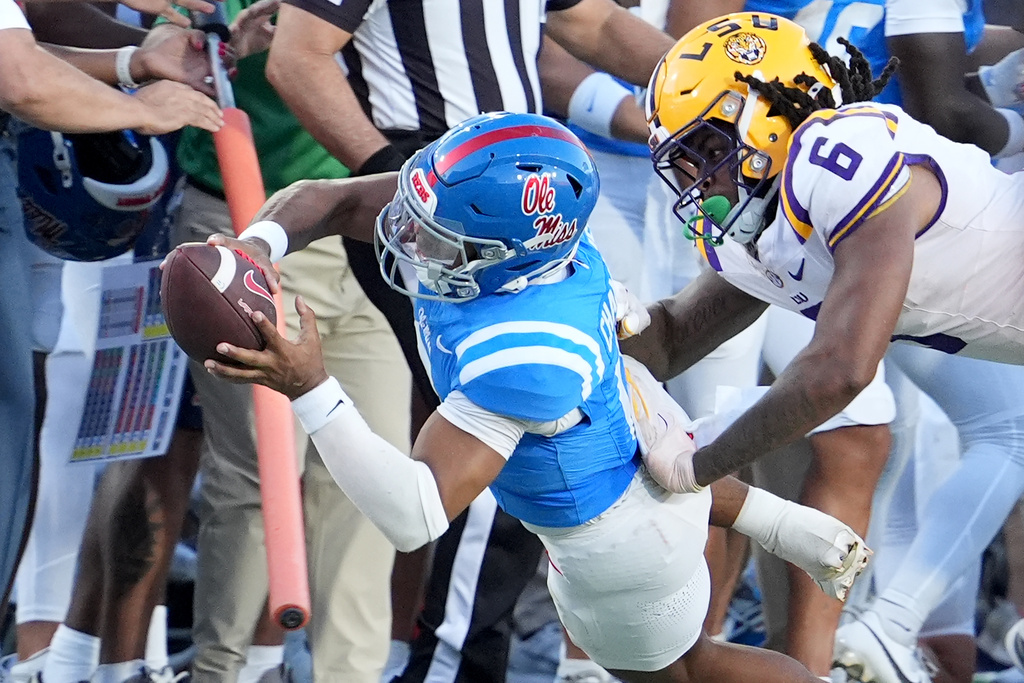Mississippi quarterback Trinidad Chambliss (6) dives for a first down while LSU defensive end Patrick Payton (6) tackles him during the second half of an NCAA college football game in Oxford, Miss., Saturday, Sept. 27, 2025. (AP Photo/Rogelio V. Solis)