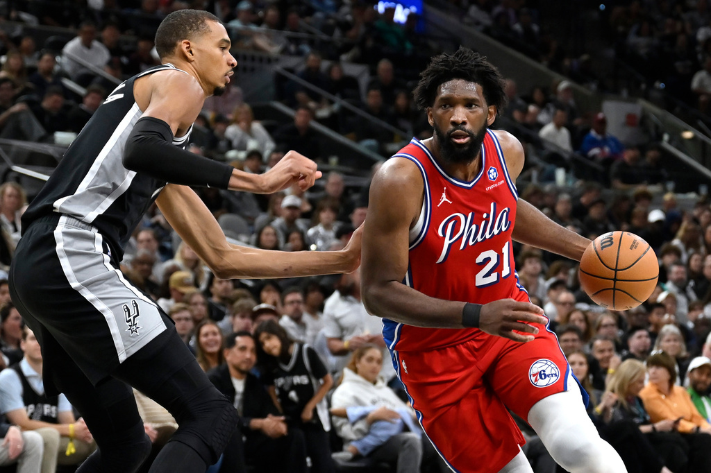 Philadelphia 76ers center Joel Embiid (21) drives against San Antonio Spurs center Victor Wembanyama, left, during the first half of an NBA basketball game, Monday, April 6, 2026, in San Antonio. (AP Photo/Darren Abate)