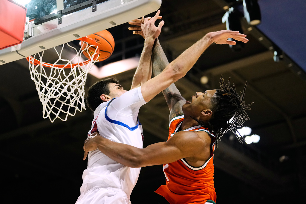 Miami forward Shelton Henderson, right, has his dunk attempt broken up by SMU center Samet Yigitoglu, left, in the first half of an NCAA college basketball game in Dallas, Wednesday, March 4, 2026. (AP Photo/Tony Gutierrez)