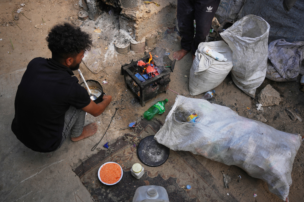 Palestinians use combustible materials collected from a garbage dump as fuel for cooking amid a shortage of cooking gas in Deir al-Balah, central Gaza Strip, Saturday, Aug. 22, 2026. (AP Photo/Abdel Kareem Hana)