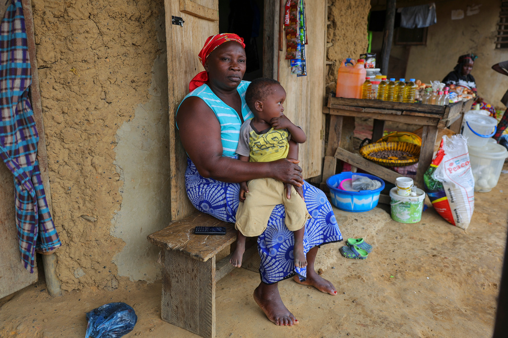 Fatama Massaley holds the son of Essah Massaley, who died during a protest in Kinjor, Liberia, July 8, 2025. (AP Photo/Misper Apawu)