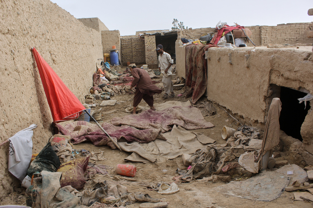 Locals inspect a damaged house following floods, landslides and thunderstorms in Kandahar province, Afghanistan, Sunday, March 29, 2026. (AP Photo/Sibghatullah)