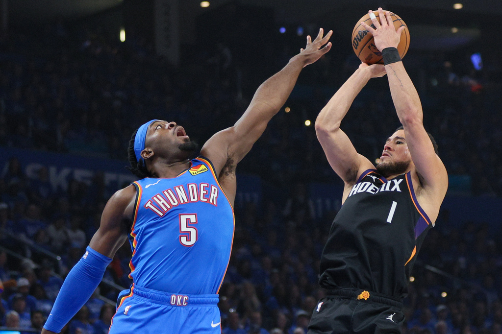 Phoenix Suns guard Devin Booker (1) looks to shoot over Oklahoma City Thunder guard Luguentz Dort (5) during the first half in Game 1 of a first-round NBA playoffs basketball series Sunday, April 19, 2026, in Oklahoma City. (AP Photo/Nate Billings)