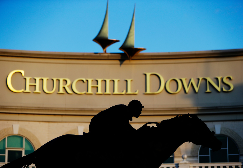 FILE - - In this May 6, 2020, file photo, a statue of Barbaro is silhouetted at the entrance of Churchill Downs in Louisville, Ky. (AP Photo/Darron Cummings, File)