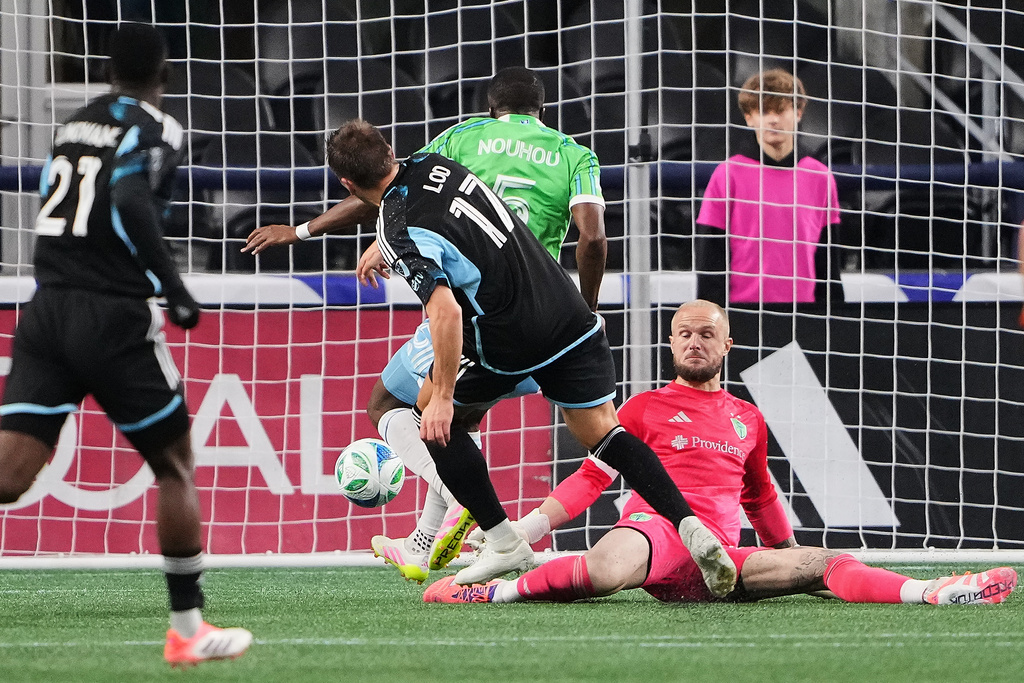 Minnesota United midfielder Robin Lod (17) scores against Seattle Sounders goalkeeper Stefan Frei, right, and defender Nouhou Tolo (5) during the first half of Game 2 in the first round of MLS soccer's Western Conference playoffs Monday, Nov. 3, 2025, in Seattle. (AP Photo/Lindsey Wasson)
