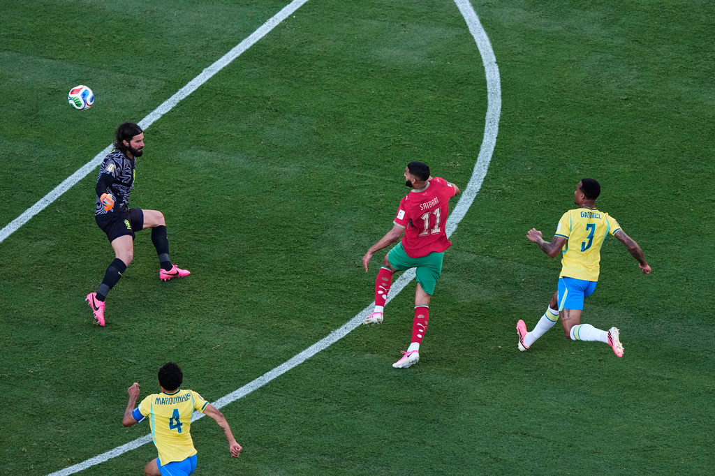 Morocco's Ismael Saibari (11) scores over Brazil goalkeeper Alisson Becker, left, as Brazil's Gabriel Magalhaes (3) and Marquinhos (4) watch during the World Cup Group C soccer match in East Rutherford, N.J., near New York, Saturday, June 13, 2026. (AP Photo/Matt Slocum)