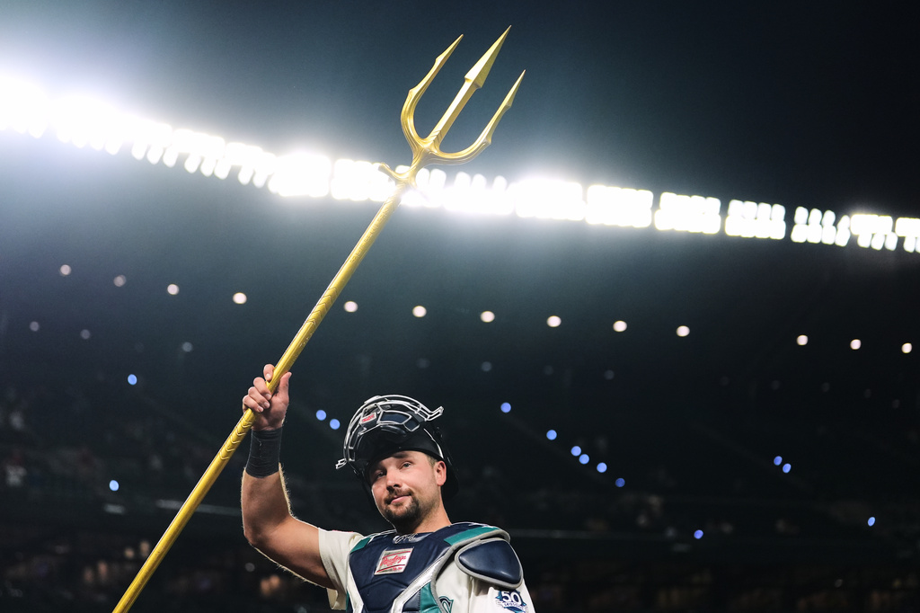 Seattle Mariners catcher Cal Raleigh lifts the trident to celebrate a win over the Philadelphia Phillies in a baseball game, Monday, Aug. 24, 2026, in Seattle. (AP Photo/Lindsey Wasson)