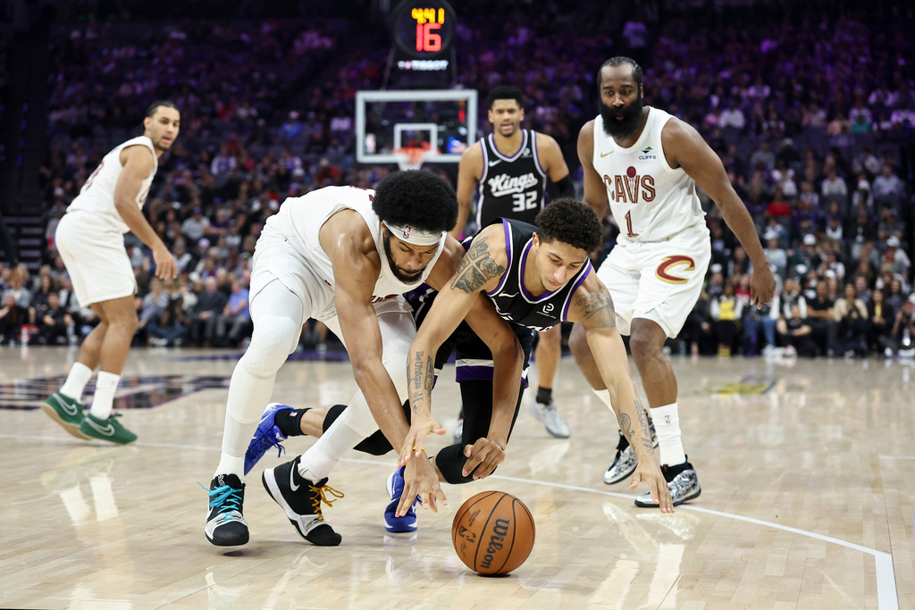 Sacramento Kings guard Nique Clifford (5) and Cleveland Cavaliers center Jarrett Allen, left, dive for a loose ball during the first half of an NBA basketball game Saturday, Feb. 7, 2026, in Sacramento, Calif. (AP Photo/Sara Nevis)