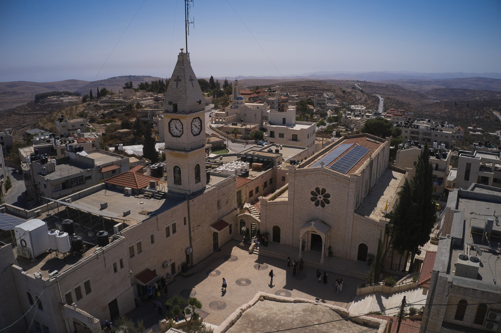 Palestinian parishioners stand outside Christ the Redeemer Church after attending a morning Mass in the West Bank village of Taybeh, Sept. 28, 2025. (AP Photo/Leo Correa)