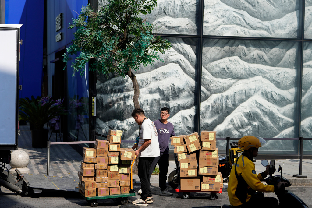 Workers deliver goods to a trendy shopping district during the National Day holidays in Beijing, China, Thursday, Oct. 2, 2025. (AP Photo/Ng Han Guan)