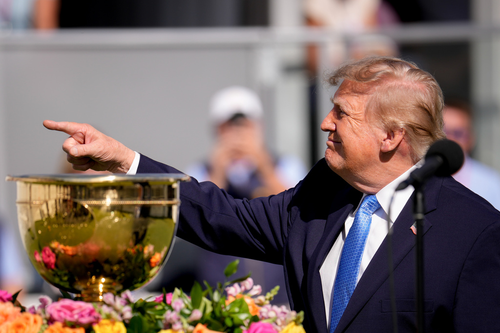 President Donald Trump points towards fans from the first tee box prior to the Presidents Cup golf tournament final round singles matches between the USA and International teams at Medinah Country Club, Sunday, Sept. 27, 2026, in Medinah, Ill. (AP Photo/Matt Slocum)