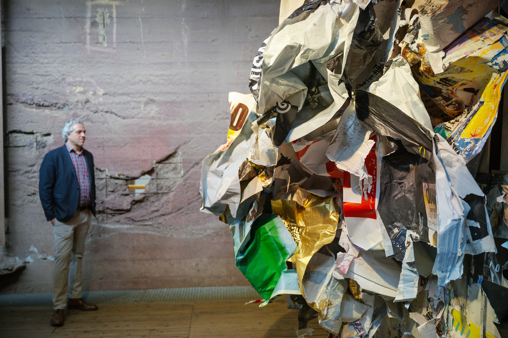 Frank Kraemer, exhibition director, stands next to the installation "Affichage Libre" by artist Joachim Romain at the exhibition Urban Art Biennale 2026 at the former ironworks Voelklinger Huette, World Cultural Heritage Site, in Voelklingen, Germany, Wednesday, May 6, 2026. (Oliver Dietze/dpa via AP)