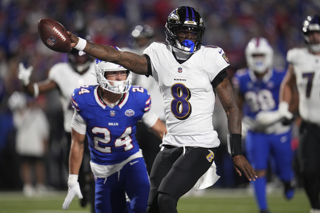 Baltimore Ravens quarterback Lamar Jackson (8) runs for a touchdown past Buffalo Bills safety Cole Bishop (24) during the first half of an NFL football game in Orchard Park, N.Y., Sunday, Sept. 7, 2025. (AP Photo/Gene J. Puskar)