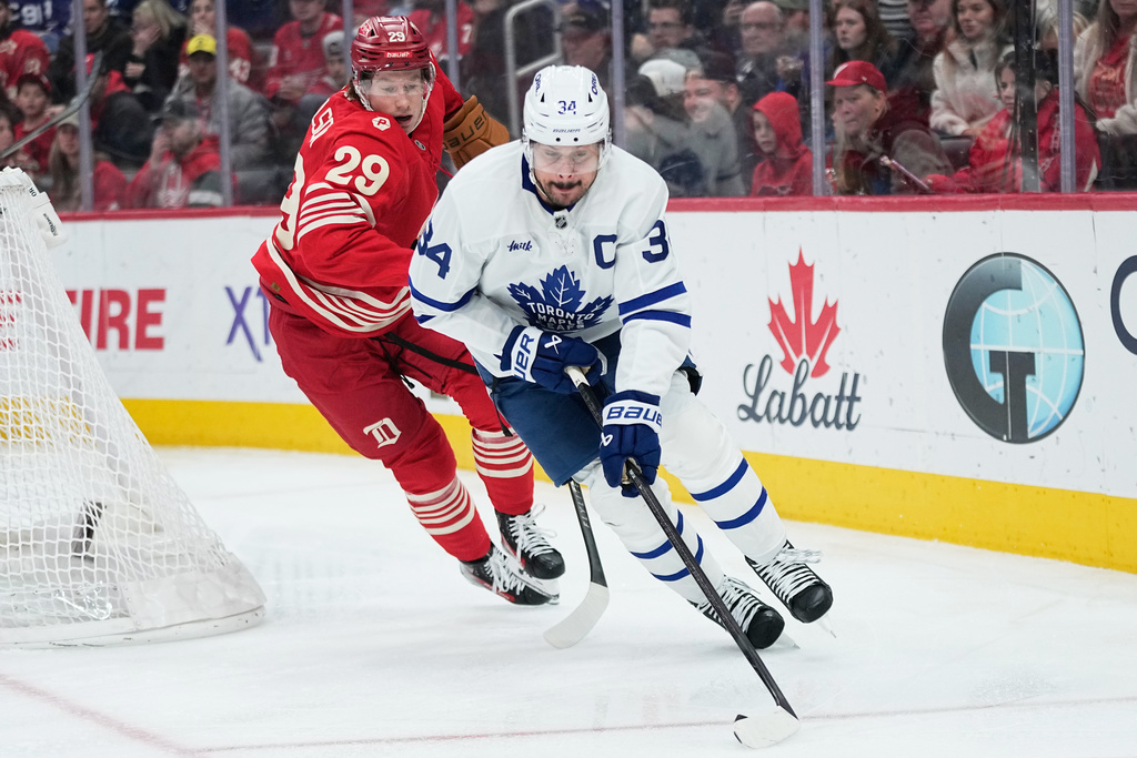 Toronto Maple Leafs center Auston Matthews, right, moves the puck against Detroit Red Wings center Nate Danielson, left, during the first period of an NHL hockey game Sunday, Dec. 28, 2025, in Detroit. (AP Photo/Ryan Sun)