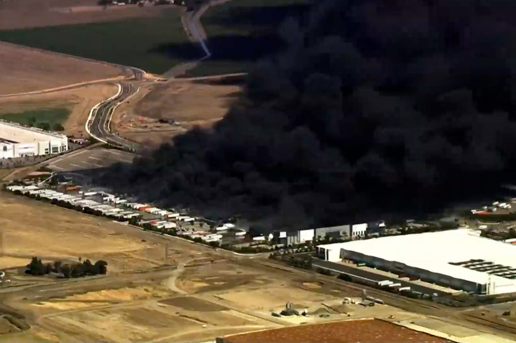 This image from aerial video shows black smoke pouring into the sky from a fire at a medical equipment warehouse in Tracy, Calif., Thursday, June 11, 2026. (KGO via AP)